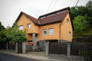 une maison jaune avec une clôture noire dans l'établissement Silent House Sovata, à Sovata