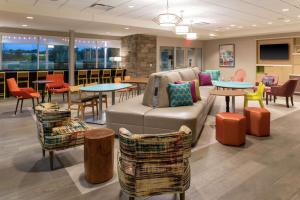 vestíbulo con sofá, mesas y sillas en Home2 Suites By Hilton Appleton, Wi, en Appleton