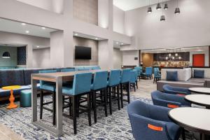 a restaurant with blue chairs and a bar at Hampton Inn & Suites Bridgeview Chicago, Il in Bridgeview