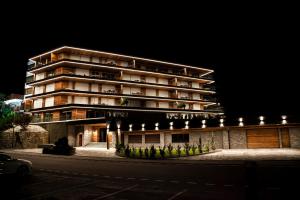 a large building with lights on the side of it at Sport Club Residences & Spa in Crans-Montana