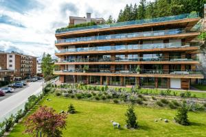 an apartment building with a garden in front of it at Sport Club Residences & Spa in Crans-Montana
