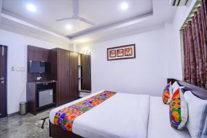 a bedroom with a bed and a television in it at FabHotel Rani Tower in Kolkata