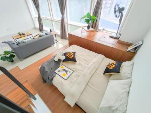een woonkamer met een bank en een stoel bij Empire City PJ Signature Suites by Manhattan Group in Petaling Jaya