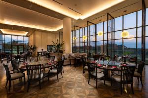 Hilton Clark Sun Valley Resort في كلارك: غرفة طعام بها طاولات وكراسي ونوافذ كبيرة