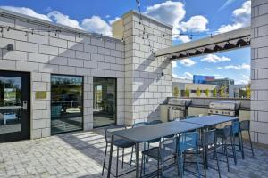 un patio con mesa, sillas y parrilla en Home2 Suites By Hilton Dayton South, en Miamisburg