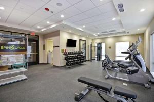 un gimnasio con cintas de correr y equipos de ejercicio en un edificio en Home2 Suites By Hilton Dayton South, en Miamisburg