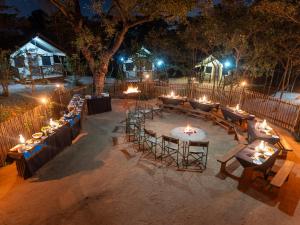 a group of tables and chairs with candles at night at Buffalo Rock Tented Camp in Hazyview
