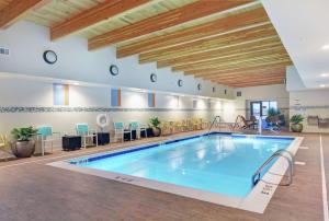 a pool in a hotel room with a large indoor swimming pool at Home2 Suites By Hilton Bettendorf Quad Cities in Bettendorf