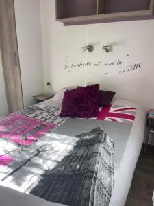 um quarto com uma cama com uma escrita na parede em Mobilhome ´Sandra ´ em Lagorce