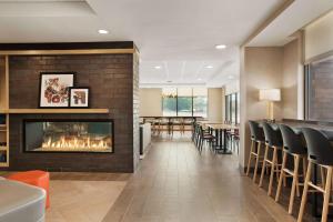 a lobby with a fireplace and a dining room at Home2 Suites By Hilton Madison Central Alliant Energy Center in Madison