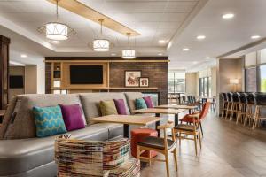 Home2 Suites By Hilton Madison Central Alliant Energy Center في ماديسون: مطعم فيه كنب وطاولات وكراسي
