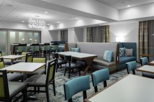 达尼丁Hampton Inn Dunedin, Fl的有桌椅和沙发的餐厅