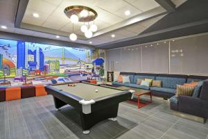 uma sala de jogos com uma mesa de bilhar e um mural em Tru By Hilton Corpus Christi South Padre Island Dr em Corpus Christi
