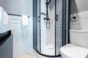 a bathroom with a shower and a toilet at Kensington Rooms - Philbeach Gardens in London