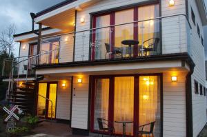 a house with a balcony with chairs and a table at Vila 16 in Palanga
