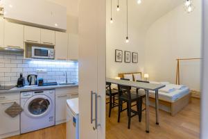 cocina y comedor con mesa y lavadora en Cassa Mist Apartment, en Budapest
