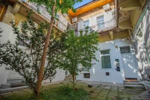 un edificio con un árbol delante en Cassa Mist Apartment, en Budapest