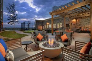 an outdoor patio with chairs and a fire pit at Homewood Suites By Hilton Denver Airport Tower Road in Denver
