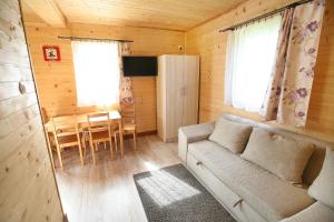 a small living room with a couch and a table at Domki ELDORADO in Dębki