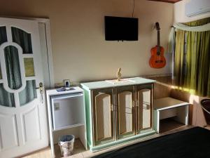 a kitchen with a sink and a tv on the wall at Suite Queen D'Arte in Florianópolis