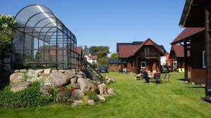 a group of people sitting in a yard with rocks at Domki ELDORADO in Dębki