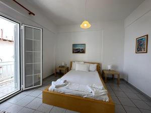 a bedroom with a bed and a large window at Anemomylos apartment sea view in Pefkohori