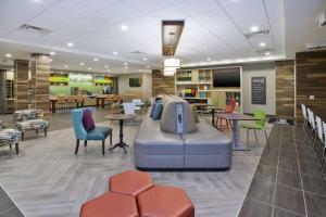 a lobby with a couch and tables and chairs at Home2 Suites By Hilton West Bloomfield, Mi in North Farmington