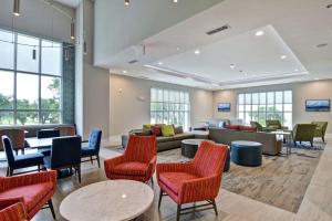 eine Lobby mit Sofas, Tischen und Stühlen in der Unterkunft Hilton Garden Inn Biloxi in Biloxi