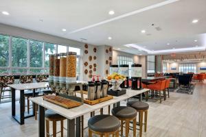 a lobby with tables and chairs and windows at Hilton Garden Inn Biloxi in Biloxi