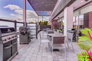 a patio with a grill and tables and chairs at Home2 Suites By Hilton Toronto/Brampton, On in Brampton
