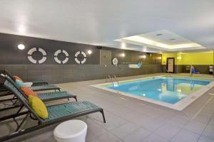 a pool in a hotel room with two chairs and a poolificialificialificialificial at Tru By Hilton Mason King's Island in Mason