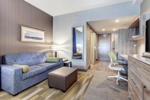 布蘭普頓的住宿－Home2 Suites By Hilton Toronto/Brampton, On，客厅配有蓝色的沙发和椅子