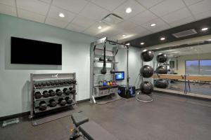 een kamer met een fitnessruimte met een tv en gewichten bij Tru By Hilton Mason King's Island in Mason