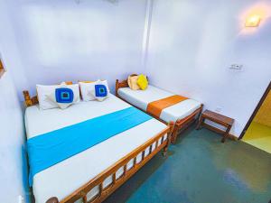 2 łóżka pojedyncze w małym pokoju z zapaleniem kręgosłupa w obiekcie Secret River Side Safari Lodge w mieście Udawalawe