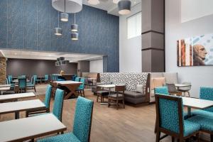 uma sala de jantar com mesas e cadeiras em Hampton Inn & Suites Rapid City Rushmore, SD em Rapid City