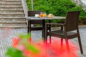 ein Tisch mit zwei Stühlen und ein Teller mit Essen drauf in der Unterkunft Suàn Hotel in Ziano di Fiemme