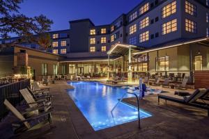 a hotel swimming pool with lounge chairs and a building at The Bevy Hotel Boerne, A Doubletree By Hilton in Boerne