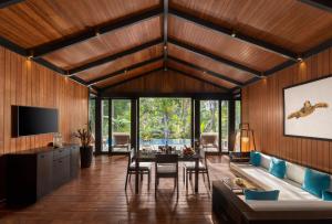 a living room with wooden walls and a table and chairs at Taj Exotica Resort & Spa, Andamans in Havelock Island