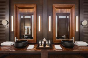 a bathroom with two sinks and two mirrors at Taj Exotica Resort & Spa, Andamans in Havelock Island