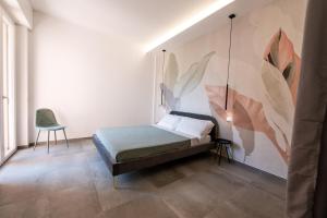 una camera da letto con un letto e un dipinto sul muro di Casa Arbanella a Varazze
