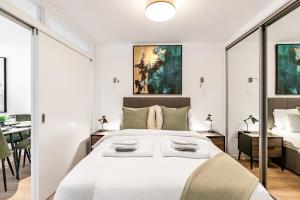 Tailored Stays - Central Cambridge, River Walk Apartments في كامبريدج: غرفة نوم بسرير ابيض كبير وطاولة