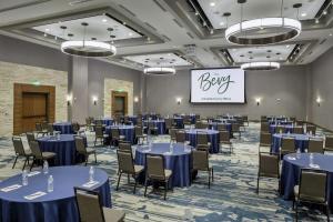 a ballroom with blue tables and chairs and a sign at The Bevy Hotel Boerne, A Doubletree By Hilton in Boerne