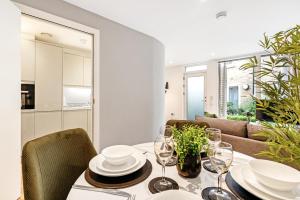 a dining room with a table with wine glasses at Tailored Stays - Central Cambridge, River Walk Apartments in Cambridge