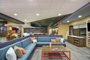 a living room with a blue couch and a coffee table at Tru By Hilton Huber Heights Dayton in Huber Heights
