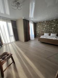 een grote kamer met een bed en een stoel bij superior villas in Tbilisi City