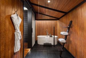 a bathroom with a white tub and wooden walls at Taj Exotica Resort & Spa, Andamans in Havelock Island