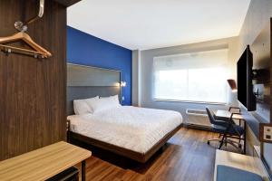 a bedroom with a bed and a desk and a window at Tru By Hilton Huber Heights Dayton in Huber Heights