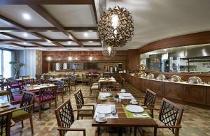 a restaurant with tables and chairs and a chandelier at DoubleTree by Hilton Istanbul Esentepe in Istanbul