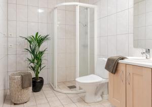 uma casa de banho com um chuveiro, um WC e uma planta em Beautiful apartment with 3 bedrooms em Sogndal