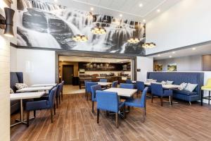 a dining room with tables and blue chairs at Hampton Inn & Suites by Hilton Québec - Beauport in Quebec City